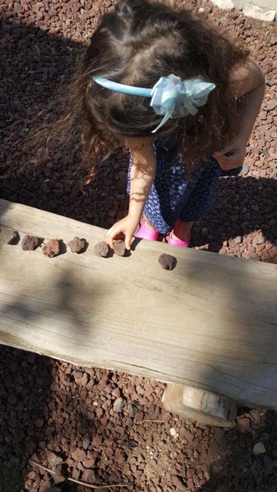 ילדה משחקת עם אבנים בטבע